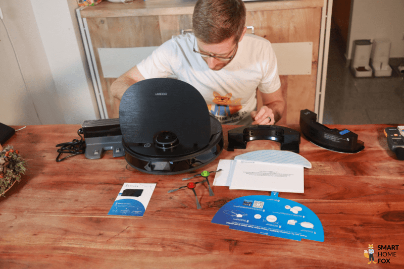 Ilia ist als TÜV Rheinland Akademie geprüfter Smart Home Experte mit einem Smart Home Gerät neben ihm zu sehen.